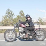 woman riding classic harley davidson motorcycle custom - brat style