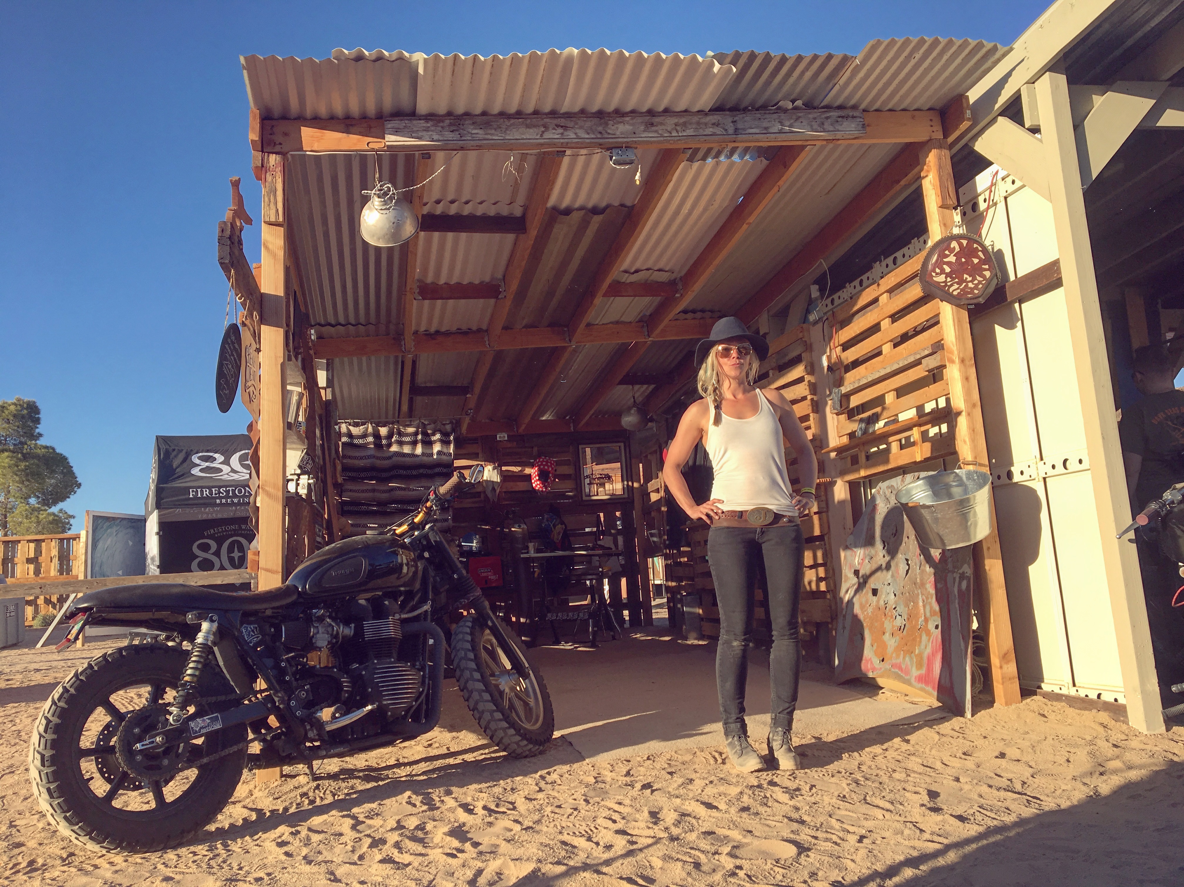 Jessi Combs with her custom Triumph Bonneville in front of the Real Deal welding booth at Babes Ride Out